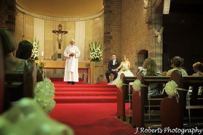 Bride and groom listing to sermon at St Mary's North Sydney - wedding photography sydney